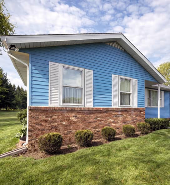 exterior house painting with freshly painted blue vinyl siding and white shutters in Dublin, Ohio